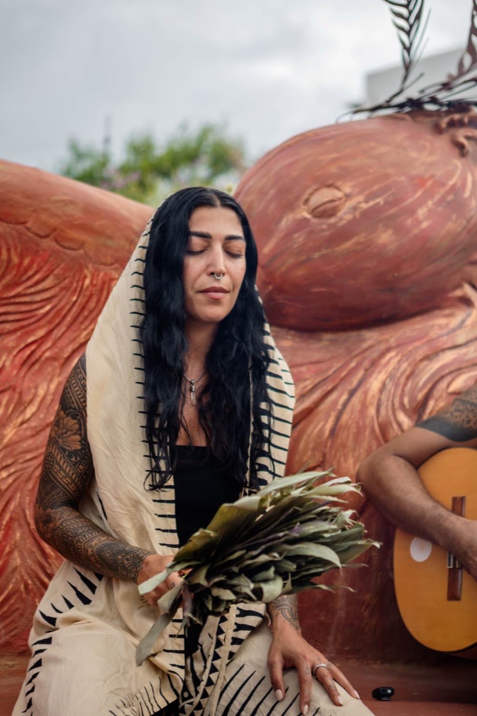 A guest holding sage in the ceremony space