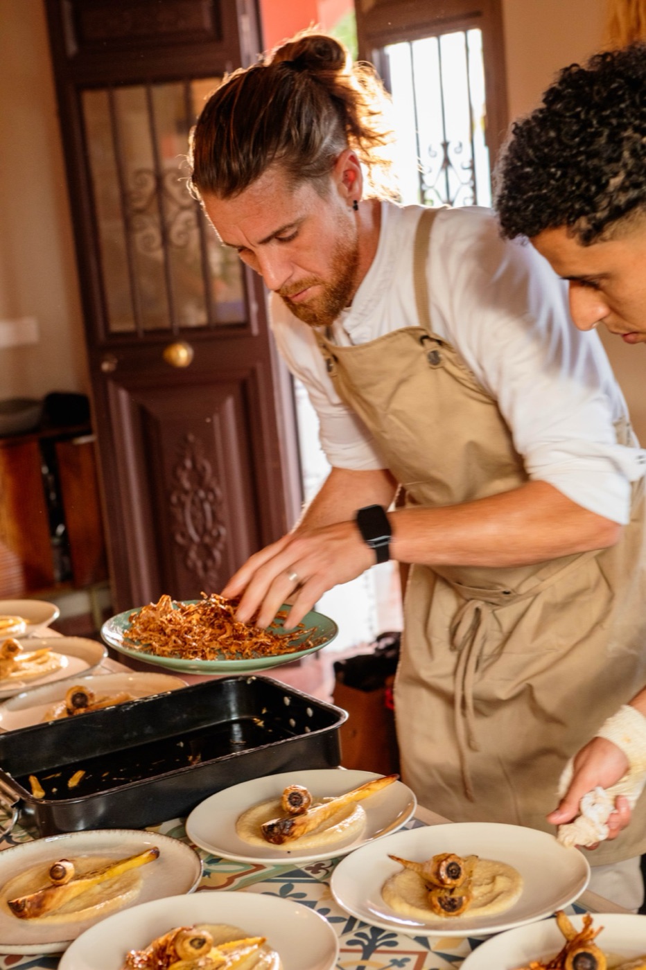 Chef plating a course in the tiled kitchen