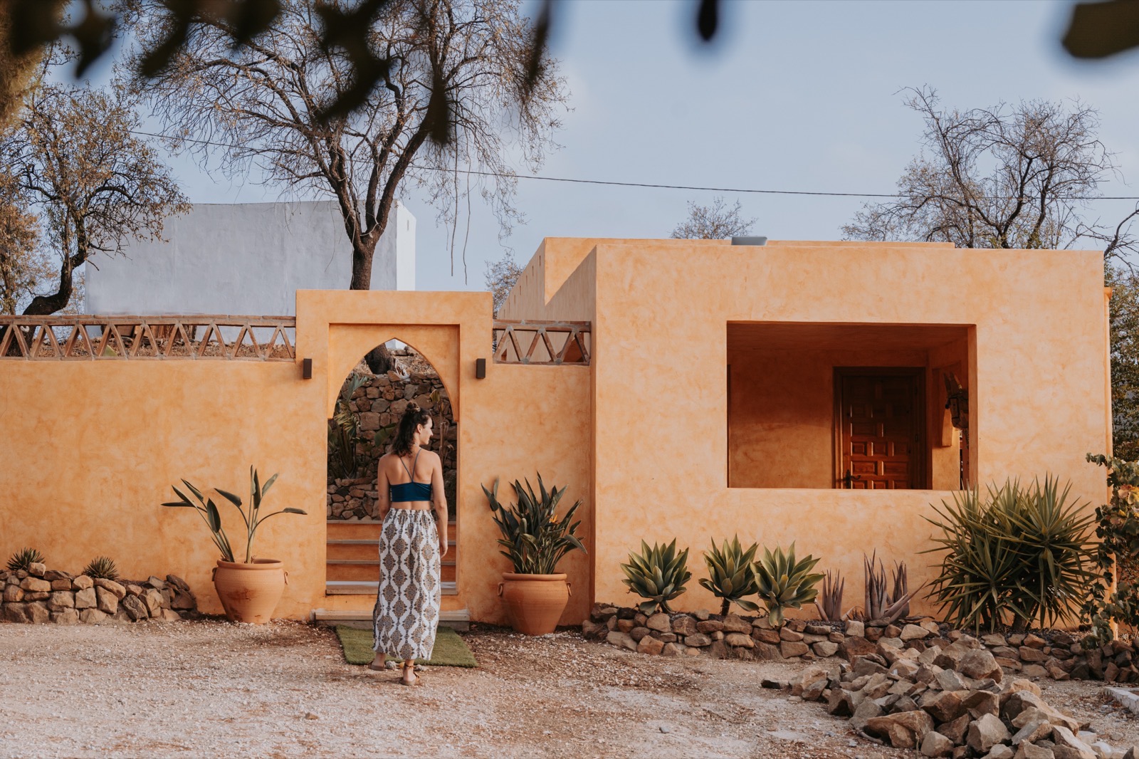 A guest walking through the arched entrance at sunset